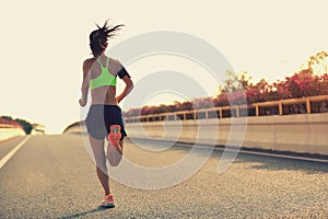 Woman runner running on city bridge road