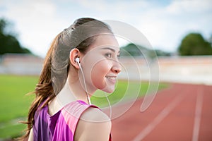 Woman runner during running exercise listing to earphones