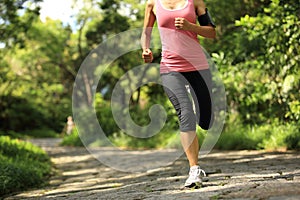 Woman runner running at forest trail