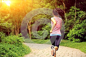 Woman runner running at forest trail