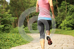 Woman runner running at forest trail