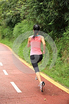 Woman runner running at forest trail