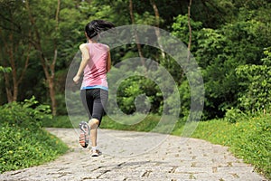 Woman runner running at forest trail