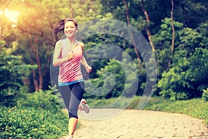 Woman runner running at forest trail