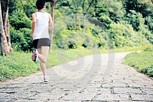 Woman runner running at forest trail