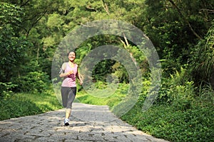 Woman runner running at forest trail