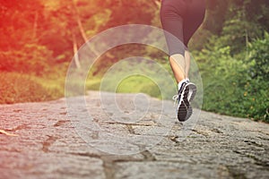 Woman runner running at forest trail