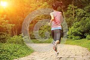 Woman runner running at forest trail