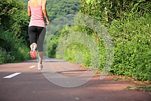 Woman runner running at forest trail