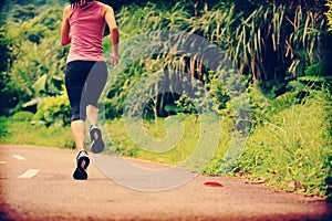 Woman runner running at forest trail