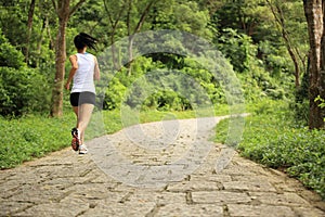 Woman runner running at forest trail