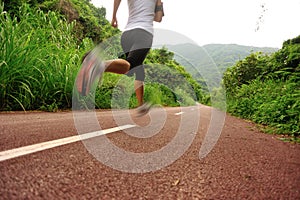 Woman runner running at forest trail