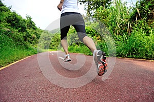 Woman runner running at forest trail