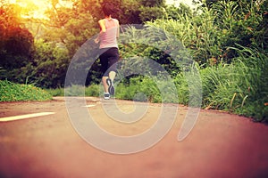 Woman runner running at forest trail