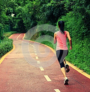 Woman runner running at forest trail