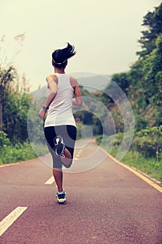 Woman runner running at forest trail