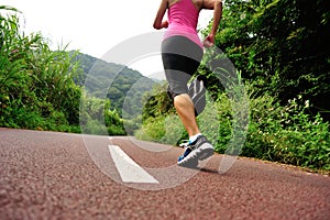 Una donna corridore correre sul foresta marciapiede 