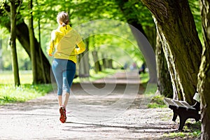 Woman runner running jogging in summer park