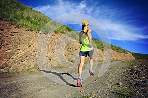 Woman runner running on mountain trail