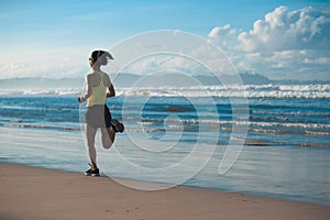 Woman runner running on sandy beach