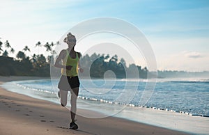 Woman runner running on sandy beach