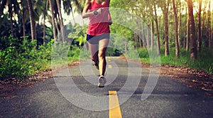 woman runner running on tropical forest trail
