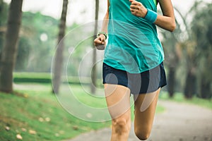 Woman runner running on tropical park trail photo