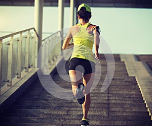 Woman runner sportswoman running up city stairs