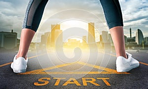 Woman runner standing on a start sign ready to run to goal and freedom on modern city for motivation begining concept