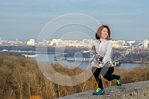 Woman runner stretching with beautiful city view