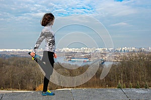 Woman runner stretching with beautiful city view