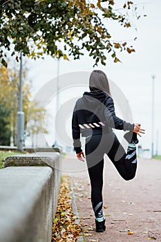 Woman runner stretching legs before run.