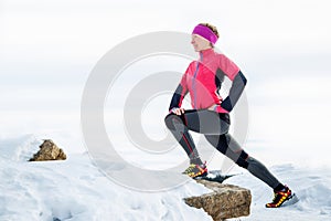 Woman runner stretching legs before run. Young athlete woman working out.