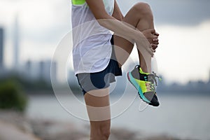 Woman runner stretching legs before running