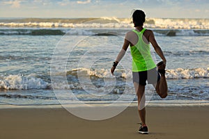 woman runner stretching legs before running on sunrise seaside