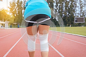 Woman runner suffering from pain in legs be injured,Hand touching her knee after jogging on track running