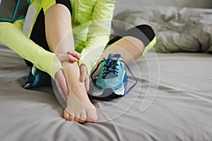 Woman runner touching foot in pain due to sprained ankle