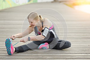 Woman runner tying laces before training. Marathon.