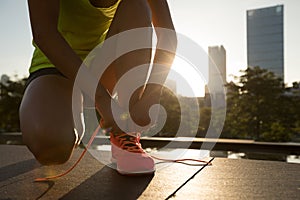 Woman runner tying shoelace before running