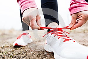 Woman runner tying sport shoes