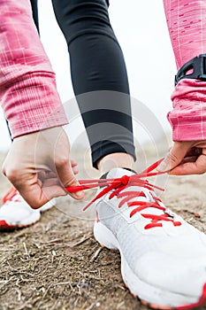 Woman runner tying sport shoes