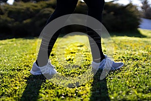 Woman runner walking in a grass field in a park at morning