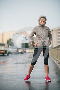 Woman runner wearing rain gear feeling determined
