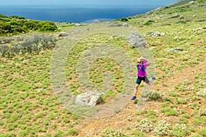 Woman running across field, Crete Island, Greece