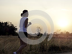 Woman running alone at beautiful sunset.