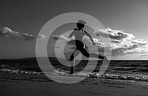 Woman running along ocean surf by water pool to keep fit and health. Woman fitness, jogging workout and sport activity