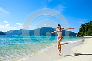 Woman running along tropical island beach