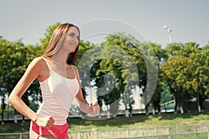 Woman running on arena track.