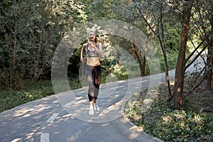 Woman running asphalt road summer park