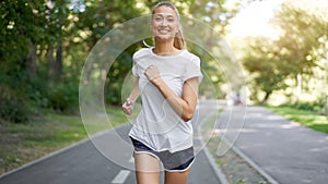 Woman running asphalt road summer park